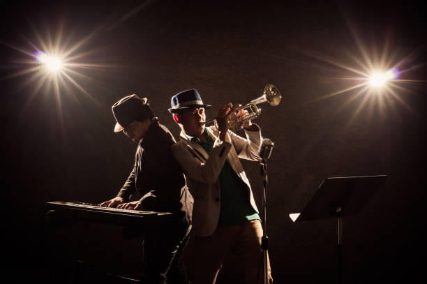 musical concept, Musicians playing a Trumpet and keyboard Musician Duo band playing a Trumpet and keyboard on black background with spot light and lens flare, musical concept piano photos stock pictures, royalty-free photos & images