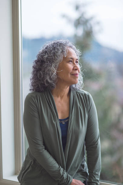 istock Woman sitting in window sill thinking 640912142