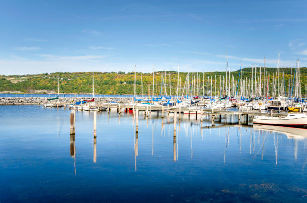 Sailing Boats in a Marina and Reflection in Water Sailing Boats in a Marina on the Shore of a Mountain Lake on Sunny Autumn Day. Seneca Lake, Upstate New York watkins glen stock pictures, royalty-free photos & images
