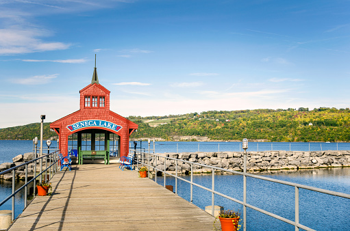 Deserted Pier with a Benches and a Red Shelter at the End. Woody Hills are Visible in Background Seneca, Lake, NY