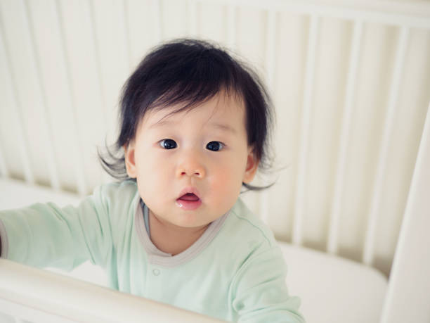 istock Baby girl stand in cot bed 640924288