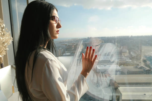 istock Woman looking cityscape through the window 640930270