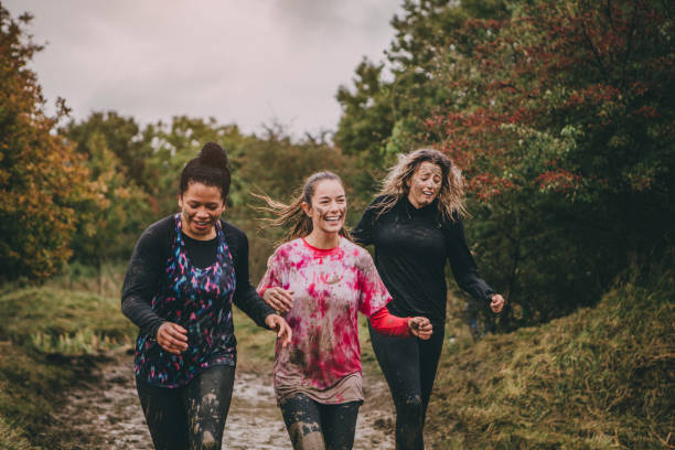 glückliche frauen laufen - laufveranstaltungen stock-fotos und bilder