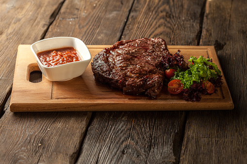Grilled steak and vegetables on aged wooden table