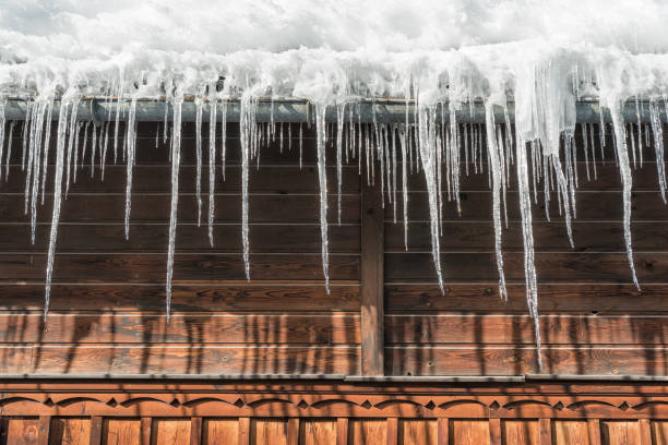 ghiaccioli appesi al tetto - mountain snow sunset house foto e immagini stock