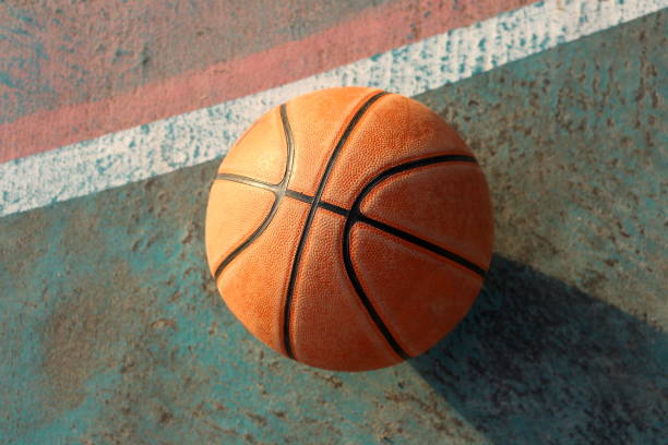 istock Basketball and shadow on the floor in twilight 640944624