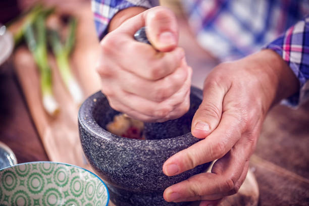 Preparing Asian Marinade in pestle and mortar with soy sauce, herbs and olive oil