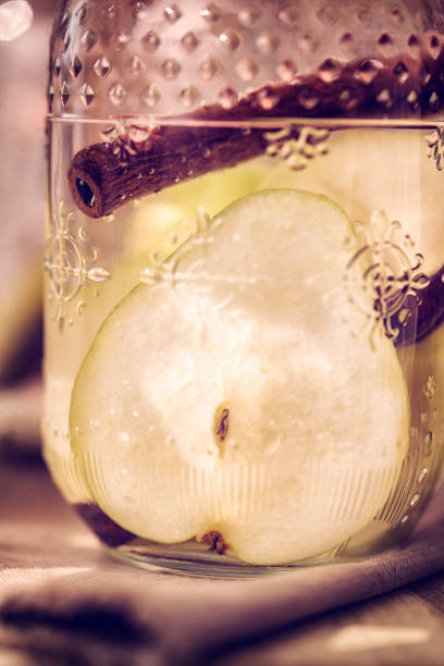 Infused water with fresh pears and cinnamon served in a glass jar.