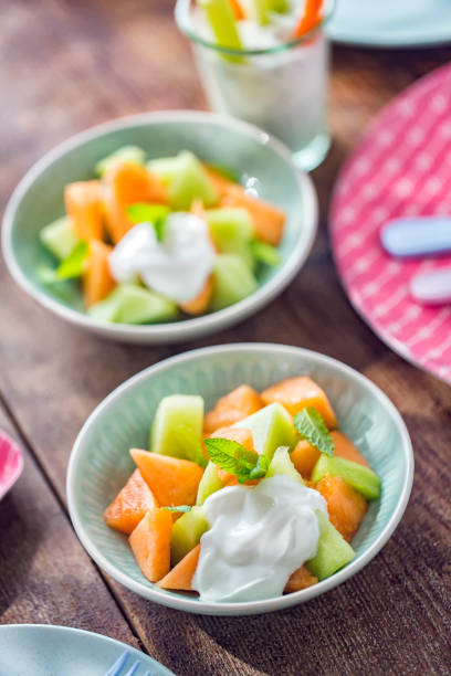 Delicious honeydew and cantaloupe melon with yogurt and mint served in a bowl.