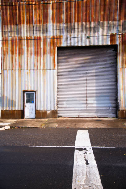 istock Old industrial building from corrugated rusty shell and big gate and small door. 640956168