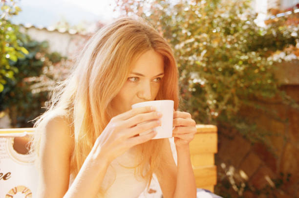 istock Young woman drinking tea in a cafe 640957236