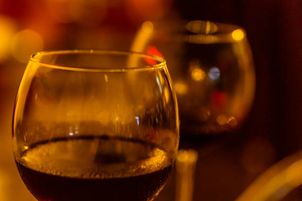 A close-up shot of two glasses of red wine, as shot at night in Santo Domingo.