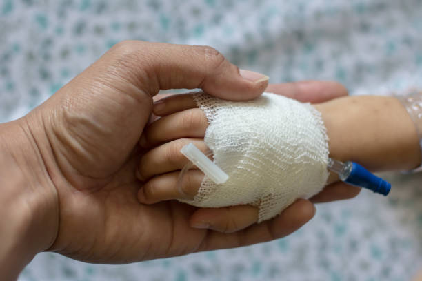 mão do paciente das crianças que recebe a solução salina iv no hostpital. - hostpital - fotografias e filmes do acervo