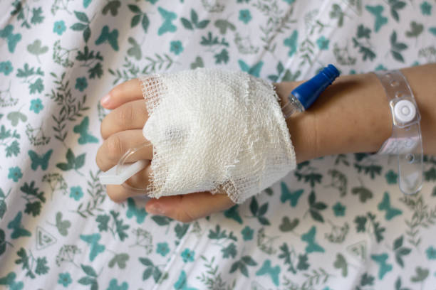 子供患者の手は hostpital の iv の塩の解決を受け取る。 - hostpital ストックフォトと画像