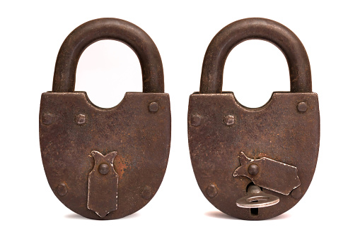 Old rusty padlock isolated on white background, key in the lock