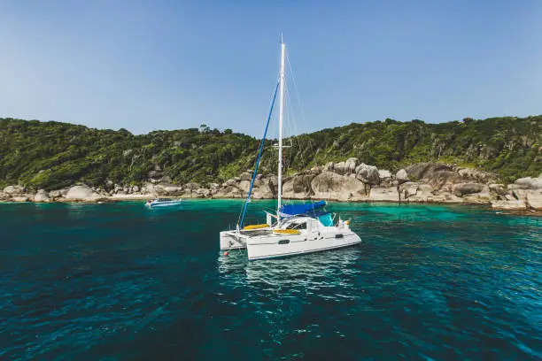 Luxury yacht in the bay near rocky island. Expensive vacation and relaxation