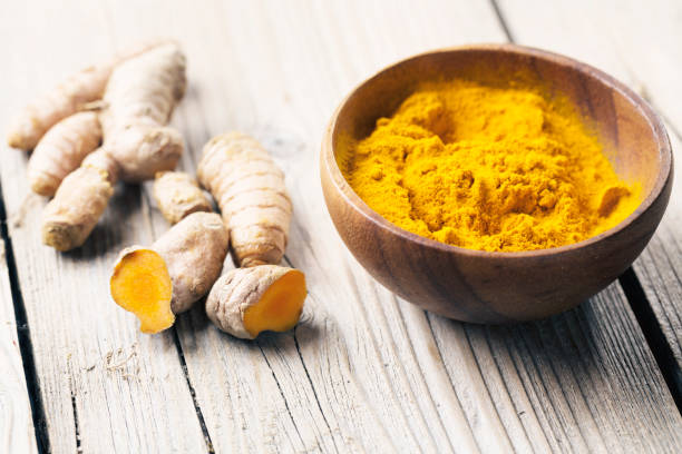 istock Spice: turmeric roots and powder on wood 640976056