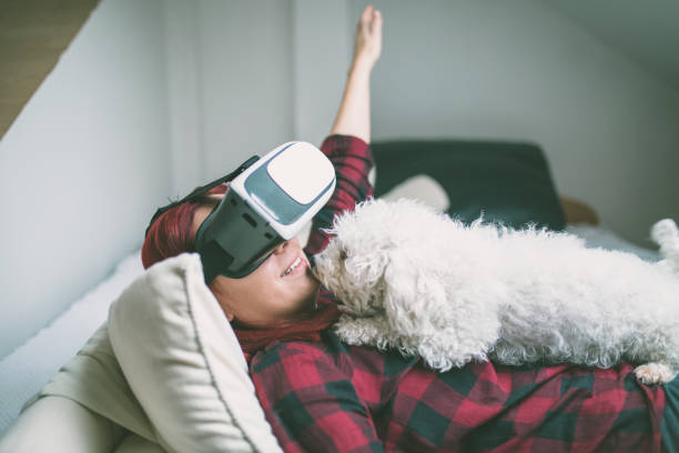 istock Woman in virtual reality helmet on bed. VR glasses. 640976422