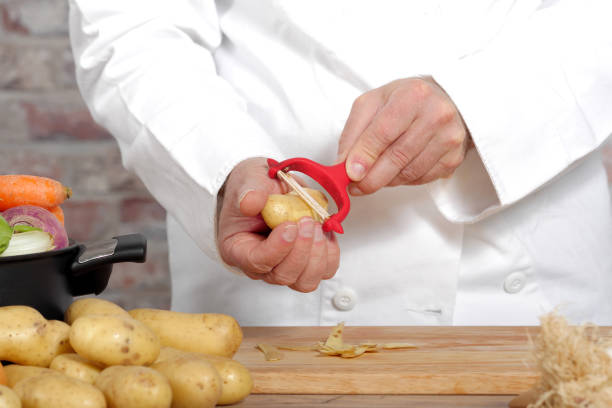 istock Hands of a man peeling potato with  peeler 640977240