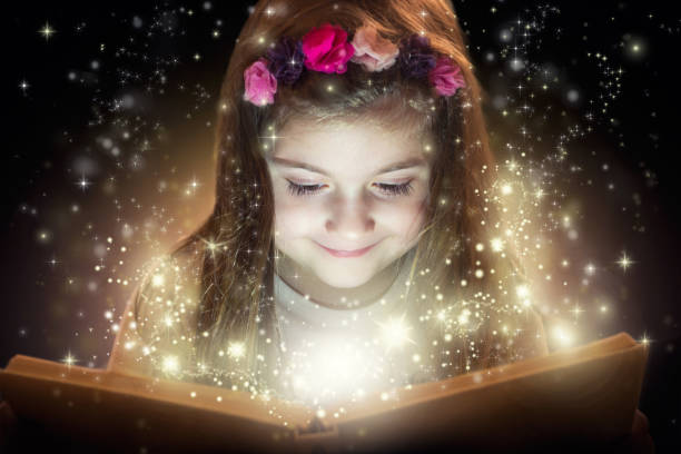 mała dziewczynka i jej magiczna książka - child bedtime imagination dark zdjęcia i obrazy z banku zdjęć