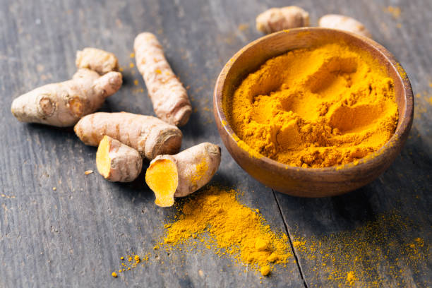 istock Spice: turmeric roots and powder on wood 640978308
