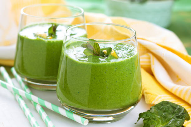 Spinach smoothie  with mint. Spinach smoothie with mint leaves and lemon on table. smoothie stock pictures, royalty-free photos & images