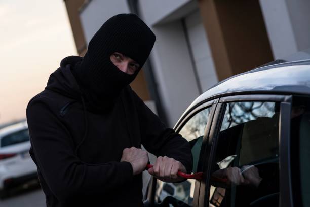 istock Auto thief in black balaclava trying to break into car 640984340