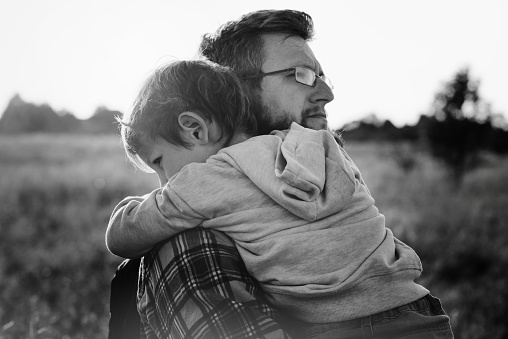 Dad hugging his son.Black and white.
