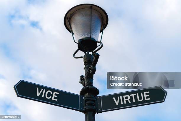 Vice Versus Virtue Directional Signs On Guidepost Stock Photo - Download Image Now - Arrow Symbol, Back to Front, Business