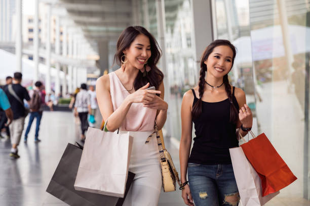 Women friends out for shopping in Bangkok city streets Thai friends in Bangkok, excited to spend a Saturday night together thailand mall stock pictures, royalty-free photos & images