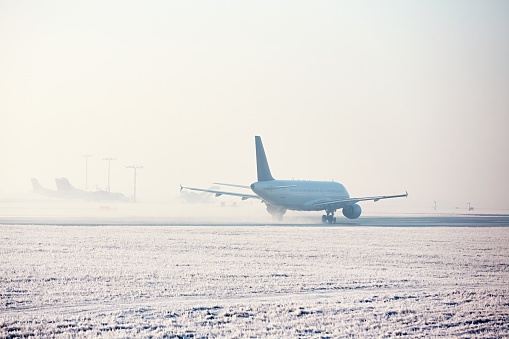 Airport in winter. Airplane is taking off in frosty day.