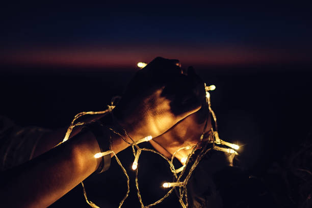 istock couple holding hands together with decorate light 640998316