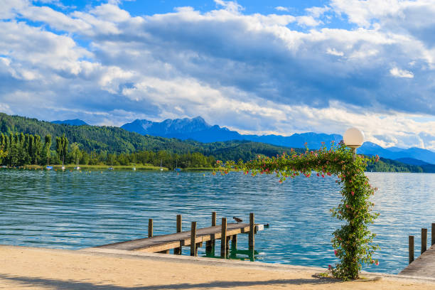 Wooden pier for mooring boats on Worthersee lake on beautiful summer day, Austria Most popular lake in Austria for summer holidays pörtschach am wörthersee stock pictures, royalty-free photos & images