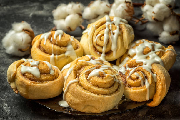 istock cinnamon rolls in a plate, on a dark background with cement cotton boxes behind. 641000610
