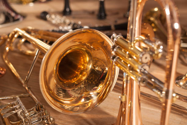 A bunch of Wind Instruments A bunch of brass  Wind Instruments laying on the wooden floor. brass instrument stock pictures, royalty-free photos & images