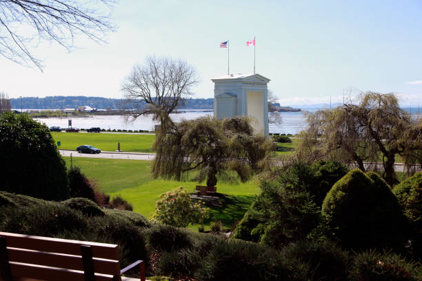 View of Siwash Rock and the seawall with one person walking, Stanley Park, Vancouver, BC