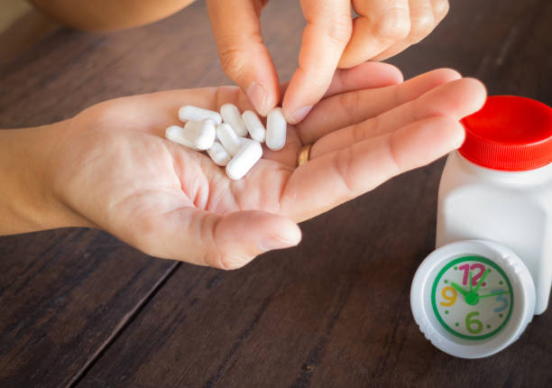 istock White pills medicine headache on hand 641014538