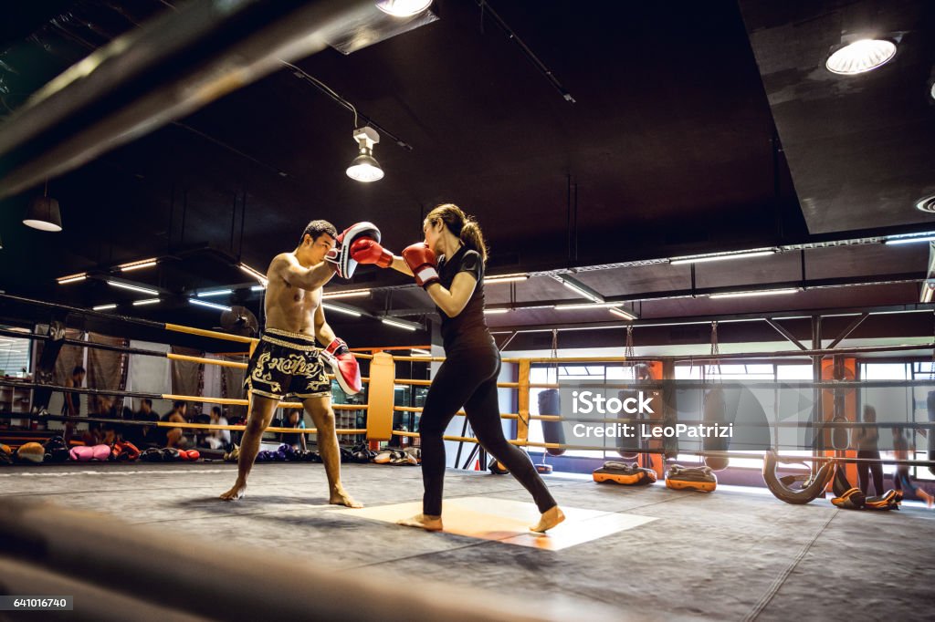 Muay Thai workout - Motivational training at the gym facility Modern gym facility in Bangkok, young athletes training for a Muay Thai class, women and men Muay Thai Stock Photo