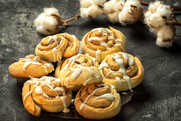 istock cinnamon rolls on the plate, on a dark cement table, cotton boxes behind. 641018000