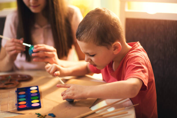 istock Brother and sister painting easter eggs at home 641023446