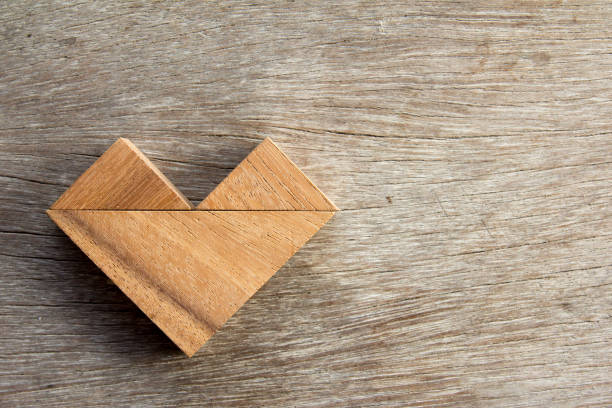 istock Tangram puzzle in heart shape on wooden background 641026228