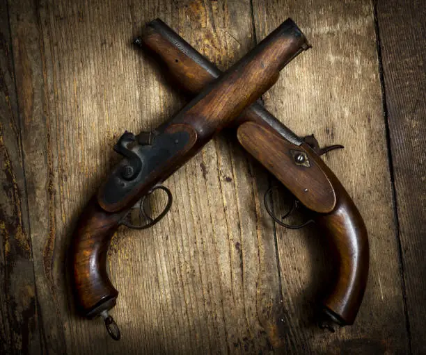 Two vintage pistols on wooden background