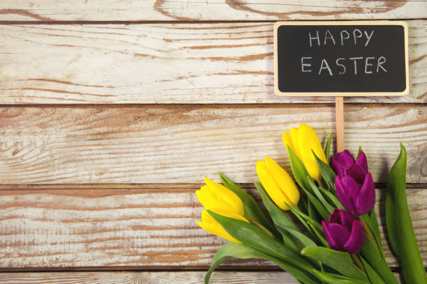 istock Yellow and purple tulips on wooden background with note happy easter 641029792