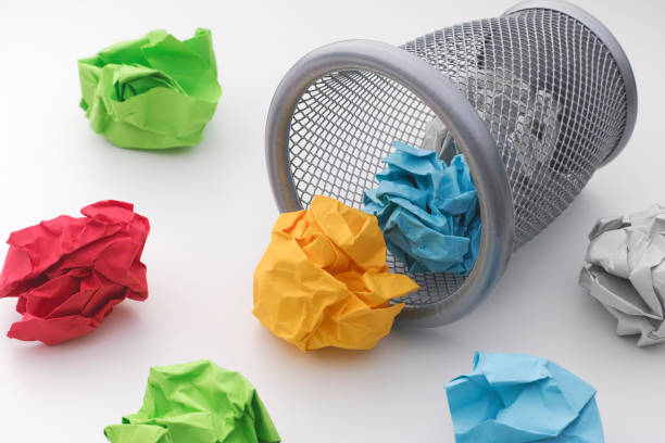 istock Colorful paper balls rolling out of trash can 641031132