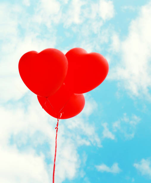 istock Red air balloons heart shape flying over blue sky background 641031866