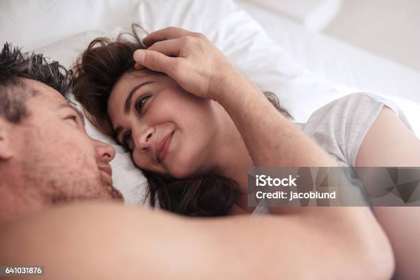 Romantic Couple Lying Together On Bed Stock Photo - Download Image Now - Bed - Furniture, Couple - Relationship, Women