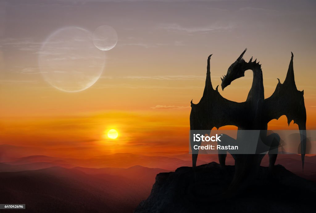 Dragon on a stone Black dragon is sitting on a stone against setting sun Dragon Stock Photo