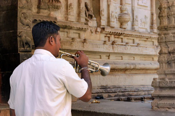 uomo indiano con una tromba nel tempio di hampi, india - indian ethnicity traditional culture architecture karnataka foto e immagini stock