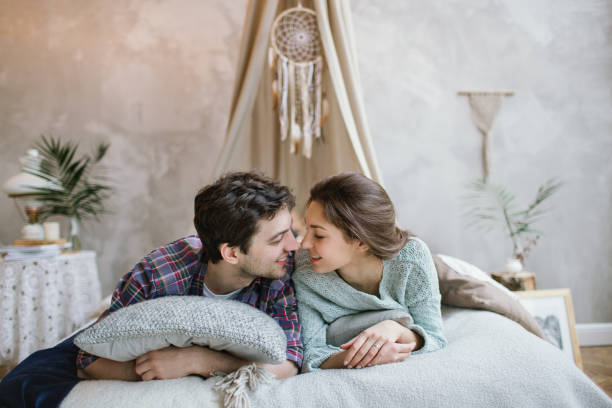 Young hipster couple having fun on handmade bed with dreamcatcher stock photo