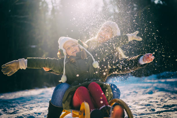 istock Cheerful mother and daughter sledging on snow 641056804